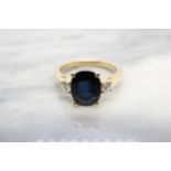A Sapphire and Diamond three stone Ring claw-set oval-cut sapphire, 3.22cts, between two brilliant-
