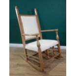 A 19th Century beechwood open Rocking Chair with carved mask finials above acanthus leaf detail, the