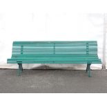 A green painted Garden Bench with wooden slats on cast iron leafage and scroll supports 6ft 9in W