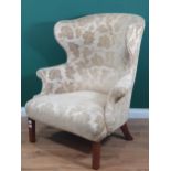 A Georgian wing Armchair with modern Damask style cream floral upholstery, and raised on squared