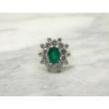 An Emerald and Diamond Cluster Ring claw-set oval-cut emerald within double frame of brilliant-cut