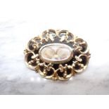 A Victorian Mourning Brooch with central oval hair picture within black enamel and gold frame,