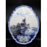 A large Delft oval Wall Plaque with polychrome painted scene of cattle by a windmill, monogram '