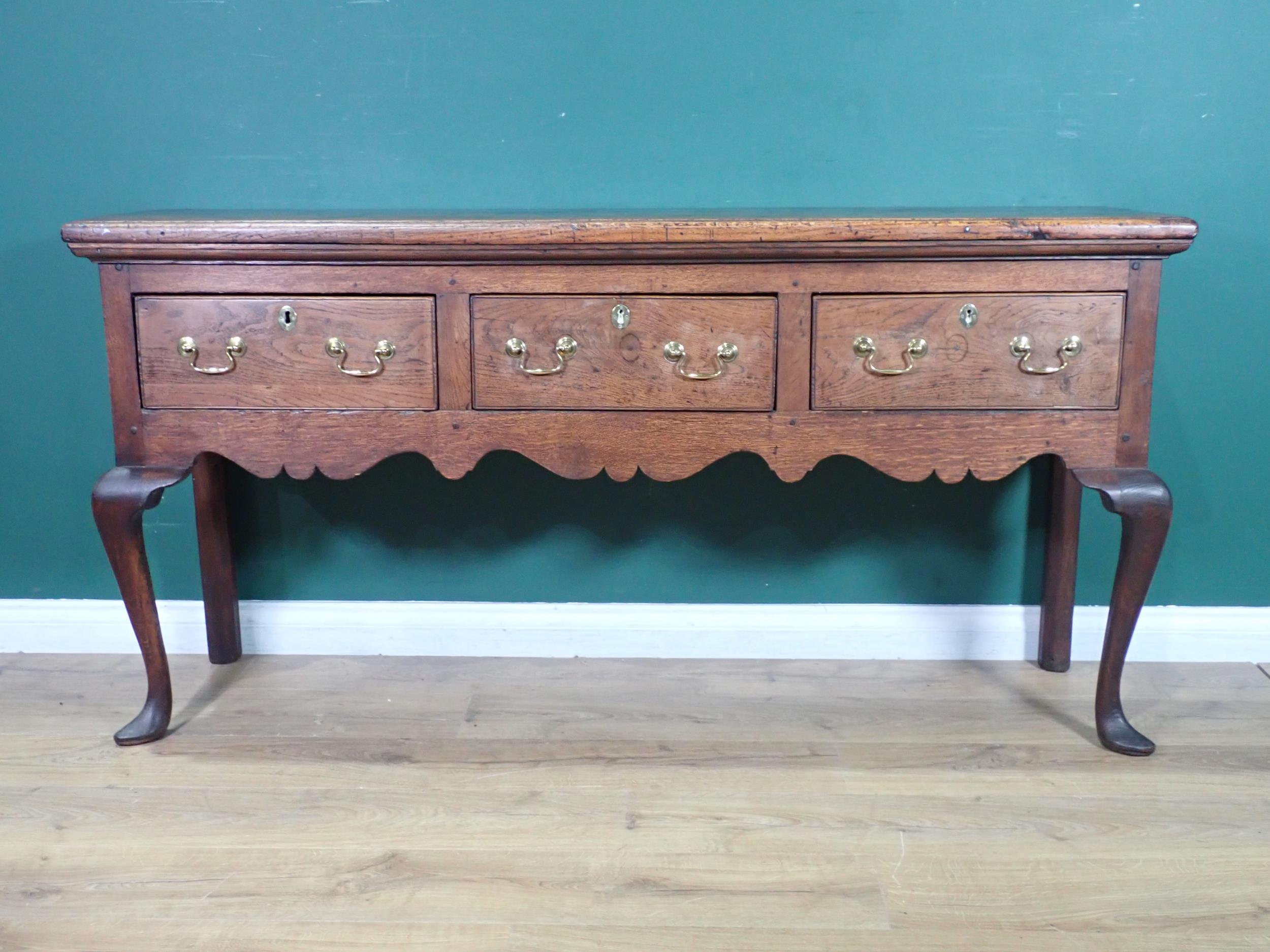 An 18th Century oak Dresser Base with thick moulded top fitted three frieze drawers above shaped