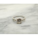 A Diamond Ring claw-set brilliant-cut stone, estimated 1.40cts, with rows of smaller stones pavé-set