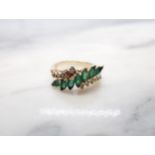 An Emerald and Diamond Ring the crossover-mount set seven marquise-cut emeralds between rows of