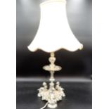 A plated Table Lamp with mask decorated column on triangular base with three cherubs holding