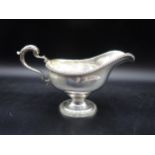 A George V silver Sauce Boat with beaded rims, leafage scroll handle on pedestal base, London