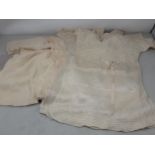 A quantity of antique Doll's Clothes including lace and knitted woollen garments