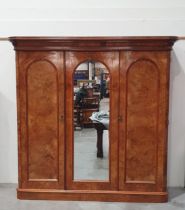 A 19th Century walnut triple door Wardrobe with central arched mirror door flanked by two arched