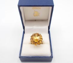 A Madeira Citrine Cluster Ring claw-set mixed-cut oval stone within a frame of marquise-cut stones