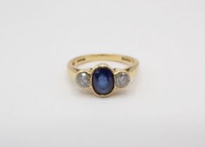 A Sapphire and Diamond three stone Ring rubover-set oval-cut sapphire between two brilliant-cut