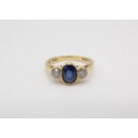 A Sapphire and Diamond three stone Ring rubover-set oval-cut sapphire between two brilliant-cut