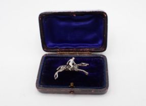 A Diamond and Enamel Horse and Jockey Brooch the jockey enamelled with blue and white hooped colours