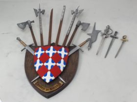 A miniature Heraldic Shield holding a collection of models of Medieval Weapons owned by Hubert De