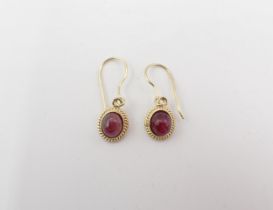 A pair of Red Spinel drop Earrings each set oval cabochon in rope twist frame, on wire fittings,