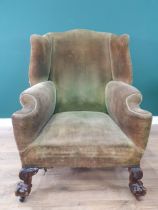 A Georgian style Wing Back Armchair with green corduroy upholstery on leafage carved cabriole