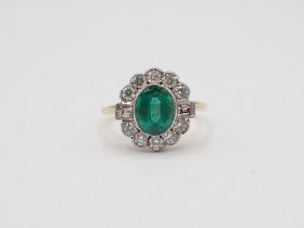 An Emerald and Diamond Cluster Ring millegrain-set oval-cut emerald within a frame of baguette and
