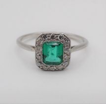 An Art Deco Emerald and Diamond Cluster Ring millegrain-set step-cut emerald within a frame of