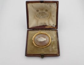 A Victorian carved shell Cameo Brooch depicting a hand in simple gold frame marked 16, 30mm x