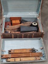 A case containing a selection of dark room equipment, folding camera stands, a Cardinal Ruby Lamp,