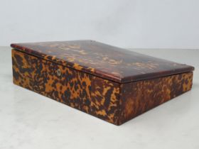 A 19th Century tortoiseshell Writing Slope, the hinged lid enclosing red velvet writing surface, and