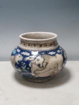 A 19th Century Qajar Bowl depicting hunting lions on a blue ground, 10in diam