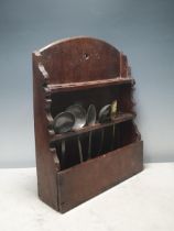 An 18th Century oak Spoon Rack with arched top and two tiers of slots for spoons and containing five