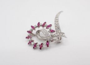 A Ruby and Diamond Wreath and Ribbon Brooch claw and pavé-set throughout with round rubies and