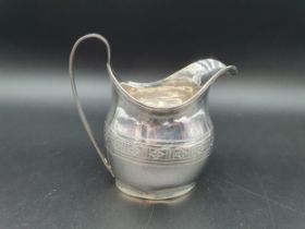 A George III silver oval Jug engraved leakage friezes with shaped cartouche and reeded rims,