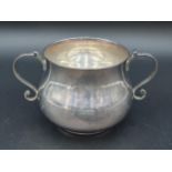 A George V Sugar Bowl of bellied form with inscription and double scroll handles, London 1934,