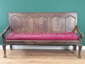 An Antique oak five panel back Settle with shaped arms, button upholstered seat raised on cabriole