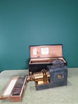A brass and painted tin Magic Lantern in box with a case of magic lantern slides