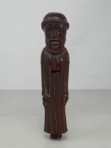 An antique carved treen Nutcracker in the form of a Monk, 8 inches long