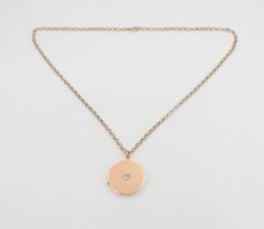 A circular gold Locket stamped 15ct, the front set single old-cut diamond on 9ct gold belcher chain,