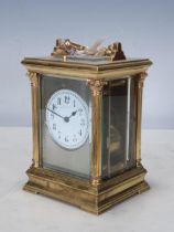 A French brass cased Carriage Clock with moulded handle, Corinthian columns on moulded base, white