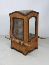 An antique Doll's Sedan Chair fitted with two glass shelves as a Display Cabinet with gold fabric