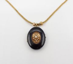 A Victorian black enamel oval Locket the front with central panel set cluster of seed pearls, 28mm x