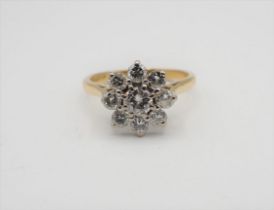 A Diamond flower Cluster Ring claw-set brilliant-cut stone within frame of eight smaller stones in