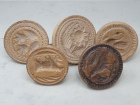 Five carved and turned wooden Butter Prints, one decorated with a swan, another with a cow,