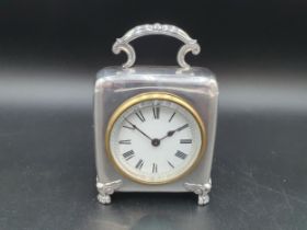 A Victorian silver cased Dressing Table Clock with white enamel circular dial on shaped supports