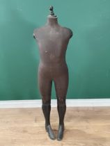 An antique Dressmaker's Mannequin with hard fabric covered body and wooden lower legs and boots,