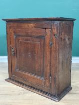 An 18th Century oak Spice Cupboard fitted fielded panel door with carved initial R.R.S enclosing