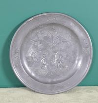 An antique pewter Plate with engraving of a basket of flowers, 9½in H