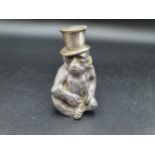 A Continental plated Table Lighter in the form of a seated monkey wearing top hat, a Christening