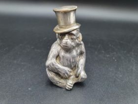 A Continental plated Table Lighter in the form of a seated monkey wearing top hat, a Christening