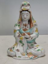 A Chinese seated Figure holding a scroll, with coloured enamel decoration, 7in H