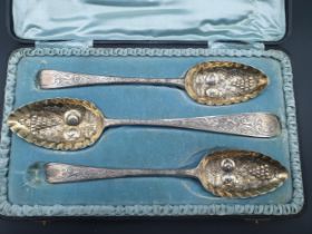 A pair of George III silver Berry Spoons with fruit embossed bowls, London 1806, and another,