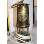 A vintage brass colliery mining lamp converted for electric use