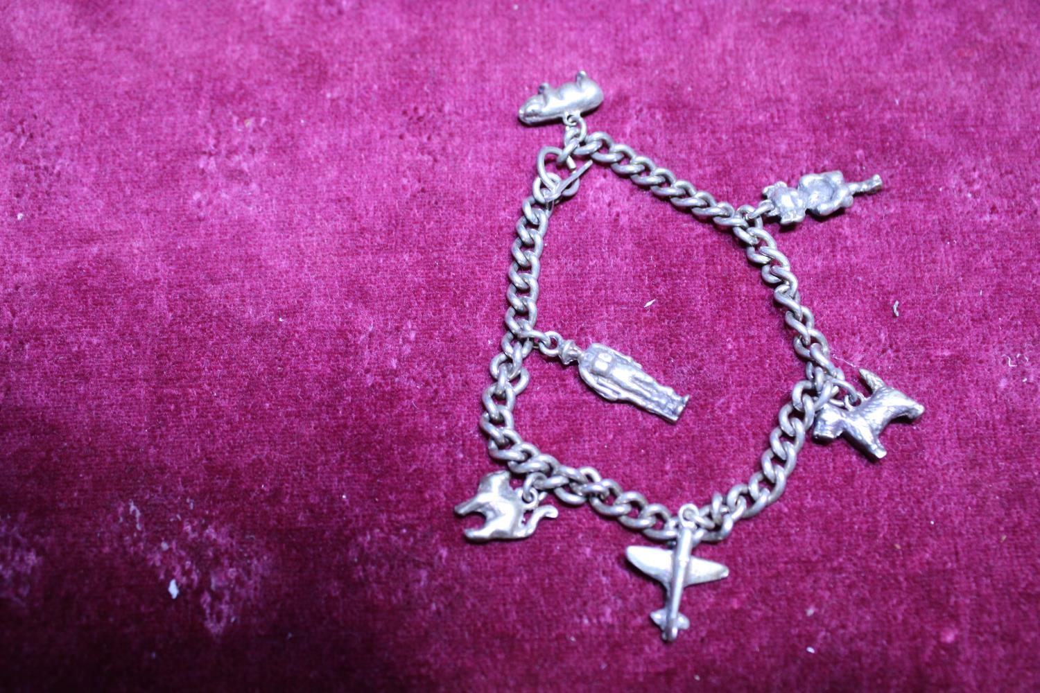 A sterling silver bracelet and white metal charms